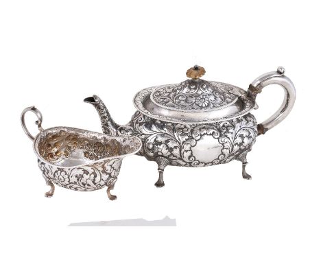 ϒA late Victorian silver tea pot and cream boat by Horace Woodward & Co Ltd, London 1895, the tea pot oval baluster with a fl