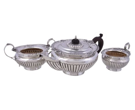 A late Victorian silver circular baluster three piece tea service by Henry Matthews, Birmingham 1899, the tea pot with an ebo