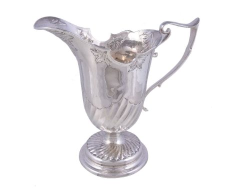 An Edwardian silver helmet shaped jug by Charles Edwards, London 1905, with an angular scroll handle, the broad spout embosse