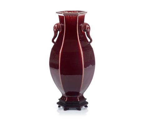 A large faceted vase, Chinese porcelain, Ox blood glaze and two elephant heads shaped handles, 20th century, Wood stand, Heig