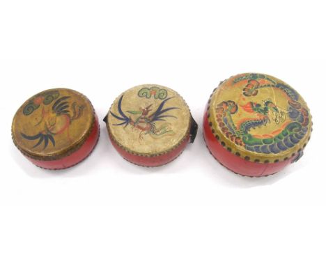 Set of three decorative Oriental drums, each with red painted shells and skins decorated with dragons and birds in flight, so