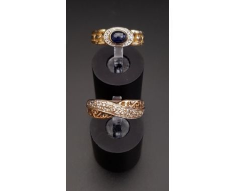 SAPPHIRE AND DIAMOND RINGthe central oval cabochon sapphire flanked by a small diamond to each side and decorative pierced sh