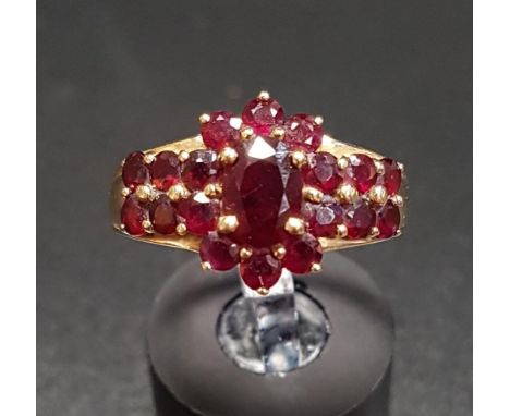 GARNET CLUSTER RINGthe central cluster flanked by further garnets to the shoulders, on fourteen carat gold shank, ring size P