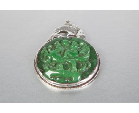 ANTIQUE CHINESE SILVER AND JADE LARGE CIRCULAR PENDANT, the circular emerald green jade panel, 3" diameter, carved in high re