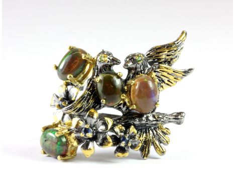 A Hana Maae silver gilt ring on the shape of a nest of birds set with cabochon cut black opals and sapphires and peridot (R.5