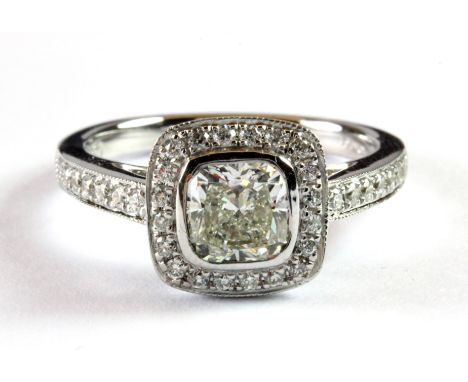 An 18ct white gold (stamped 750) ring set with a cushion cut champagne centre diamond surrounded by diamonds and diamond set 