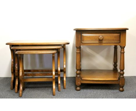 A nest of three Ercol type oak tables, W.57cm, H. 42cm, with a similar single drawer side table.