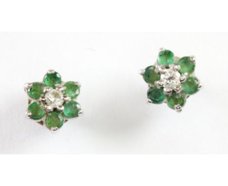 A pair of 9ct white gold diamond and emerald cluster earrings.