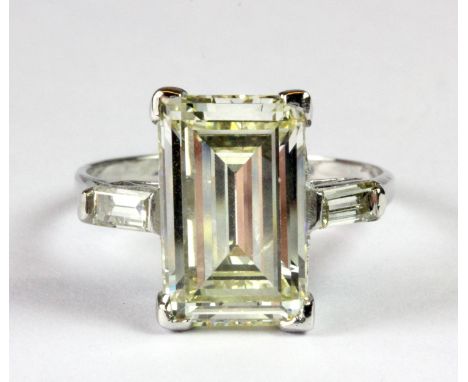 A superb white metal (tested 18ct gold) ring set with a high quality 5ct baguette cut champagne diamond with diamond set shou