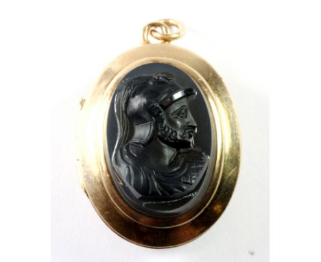 A lovely Edwardian yellow metal (tested 15ct gold) portrait locket pendant, set with a carved black hardstone cameo on the fr