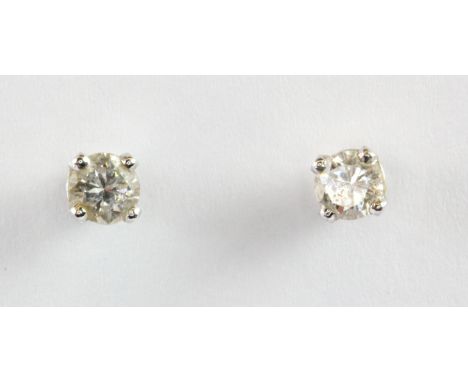 A pair of white metal mounted (tested minimum 9ct gold) diamond stud earrings.