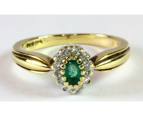 A 9ct yellow gold emerald and diamond cluster ring (K.5).