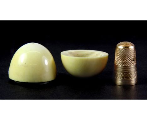 A 19thC ivory egg box containing a gold thimble. H.3.5cm