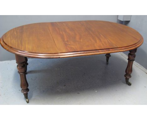 VICTORIAN MAHOGANY EXTENDING DINING TABLE of oval form, having moulded top with two additional leaves and metal winder above 