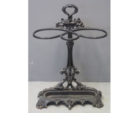 VICTORIAN CAST IRON STICK AND UMBRELLA STAND having moulded fruit and berry decoration with grotesque mask mounts and fitted 