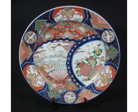 JAPANESE ARITA FINELY ENAMELLED POLYCHROME CHARGER, depicting Mount Fuji landscape with cranes in flight in a fan shaped pane