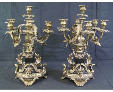 PAIR OF 20TH CENTURY YELLOW METAL CLASSICAL DESIGN FOLIATE SIX BRANCH TABLE CANDELABRUM having vase shaped stems on an ebonis