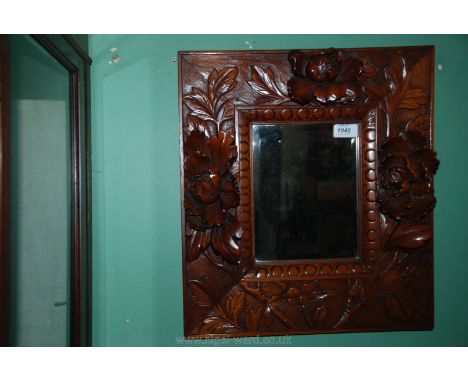A small bevel plated Mirror in a heavily carved oriental frame, 18 1/2'' x 16 1/4''.