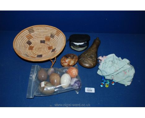 A raffia basket containing reproduction powder flask, marbles, marble eggs, etc.