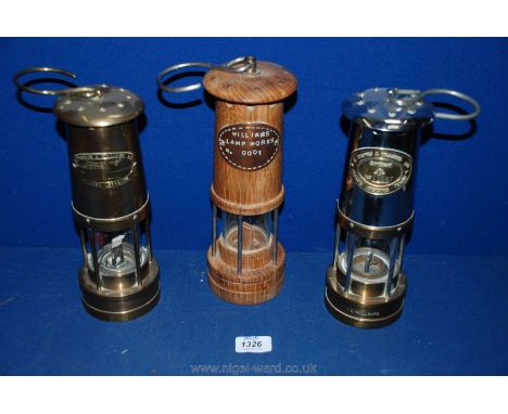 Three Davy lamps including one of wood for Williams Lamp Works, no. 0001 and two of brass by E. Thomas & Williams, Aberdare.