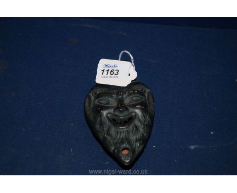A black glazed terracotta Satyr Oil Lamp, 13 cms tall.