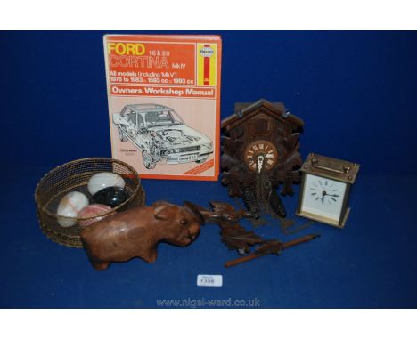 A wooden Cuckoo clock with weights, Geneve quartz clock, small carved Capybara and a Ford Cortina 1.6 and 2.0 Mark IV Book