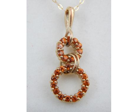 A 9ct yellow gold Maderia garnet drop pendant, suspended on a 9ct yellow gold chain. 