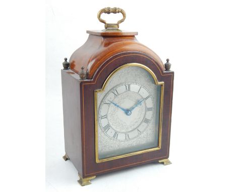 A early 20th century mahogany bracket type mantel clock, the silvered foliate engraved chapter ring set out with Roman numera
