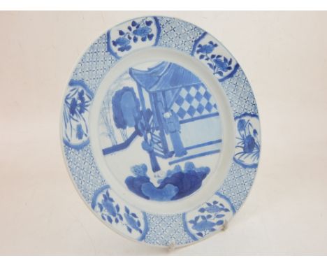 A late 17th / early 18th century Chinese Kangxi period blue and white dish, painted to the central roundel with a scholar and