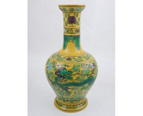 A Chinese yellow ground baluster vase with elongated neck, decorated with a dragon and phoenix chasing a flaming pearl amongs