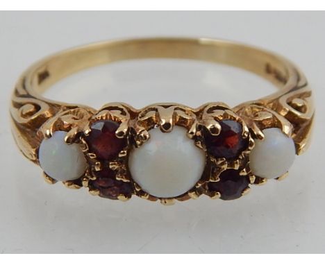 A 9ct yellow gold, opal and garnet set dress ring. 