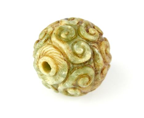 A Chinese large carved moss green and celadon and white jade bead, 6cm diameter, 7.5cm circumference.