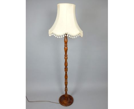 Stained, turned beech standard lamp and shade with turned baluster column, circular foot.