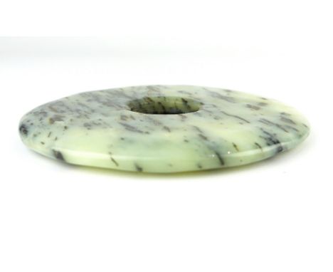 A Chinese celadon jade with dark grey speckled striations, pi disc, 9.5cm dia.