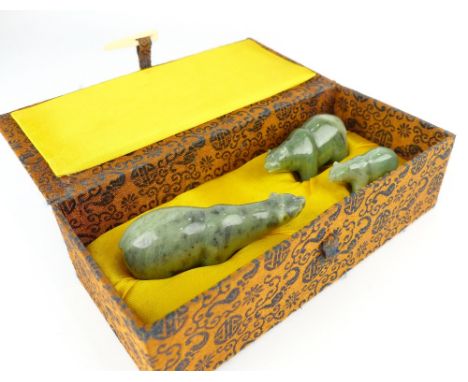 A Chinese set of three carved green jade beads of graduating size in fitted silk box.