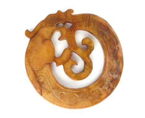 A Chinese pale tobacco brown jade carved and pierced dragon bi disc, 8.5cm dia.
