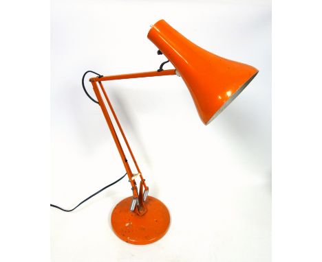 Orange anglepoise lamp on a circular base 