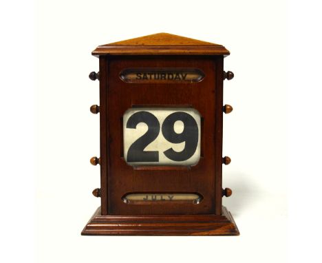 Late Victorian mahogany perpetual desk calendar of architectural form, with 3 glazed apertures displaying canvas date roller,