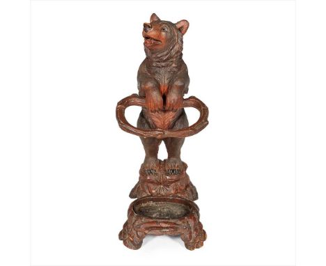 BLACK FOREST CARVED BEAR STICK STAND LATE 19TH CENTURY the standing bear holding a naturalistic stick support, above a base w