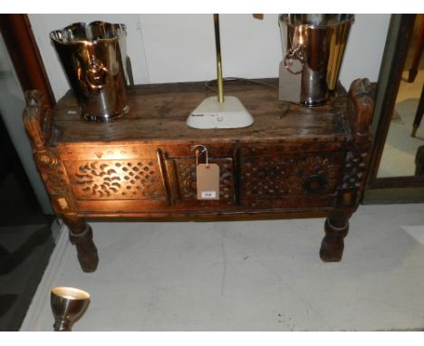 An Indonesian teak bench, with central cupboard door, raised on turned supports. H: 66cm W: 87cm D: 37cm