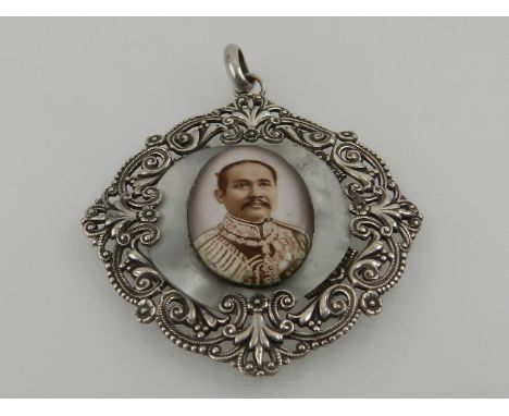 A white metal pendant, decorated with portrait set on mother of pearl to centre