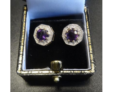 PAIR OF AMETHYST AND DIAMOND EARRINGSthe central round cut amethyst on each within textured surround set with two small diamo