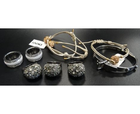 SELECTION OF FASHION JEWELLERY comprising three crystal set DKNY bombe style rings in silver tone, a silver tone Michael Kors