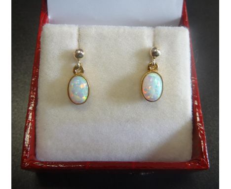 PAIR OF OPAL DROP EARRINGSthe oval cabochon opals in nine carat gold 