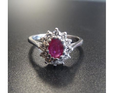 RUBY AND DIAMOND CLUSTER RINGthe central oval cut ruby approximately 0.5cts in twelve diamond surround totalling approximatel