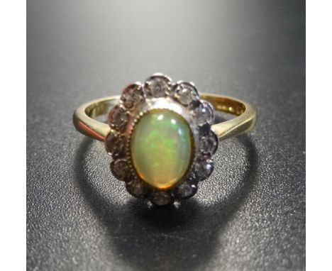 OPAL AND DIAMOND CLUSTER RINGthe central opal in twelve diamond surround, on eighteen carat gold shank, ring size O 