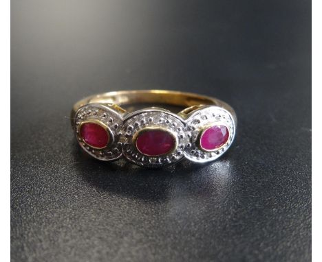 RUBY AND DIAMOND DRESS RINGthe three oval cut rubies in textured surround set with small diamonds, on nine carat gold shank, 