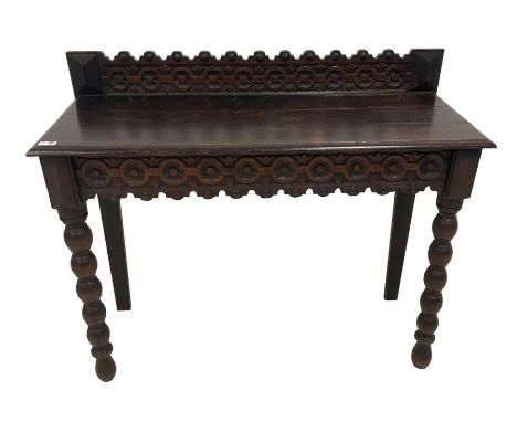 Late 19th century gothic revival oak side table the raised back carved with repeating rosette and fleur-de-lis motifs, the re