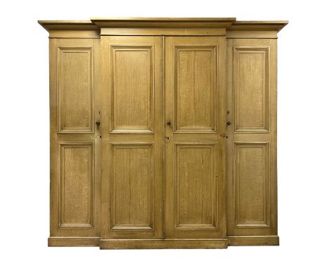 Late 19th century scumbled pine breakfront triple wardrobe or housekeepers cupboard, projecting ovolo cornice, central panell