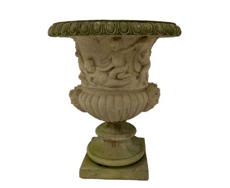 Composite stone Campana shaped garden urn, the egg and dart edge over a relief frieze depicting mischievous putti and bacchic